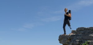 man with prosthetic leg climbing a mountain