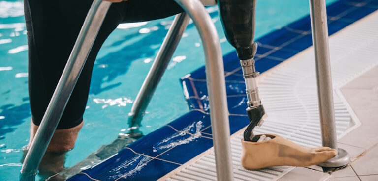 swimmer with prosthetic leg exiting pool