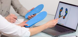 Doctor consulting patient on custom orthotic insoles in a clinic for a personalized custom fit