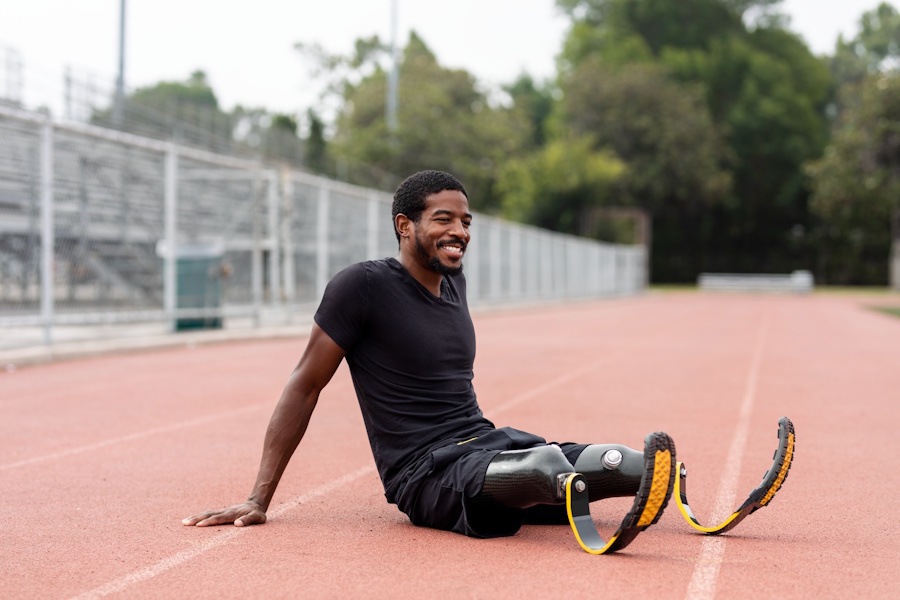athlete sitting on ground with running blades